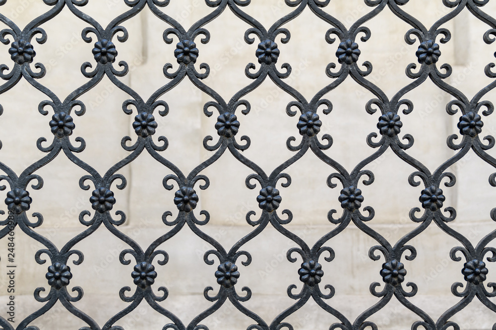 Background of black metallic fence and beige wall Background of black metallic fence and beige wall