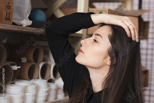 young pretty girl, student, hipster, doing a startup, working in an office or library, browsing dusty shelves with cardboard boxes in typography photo