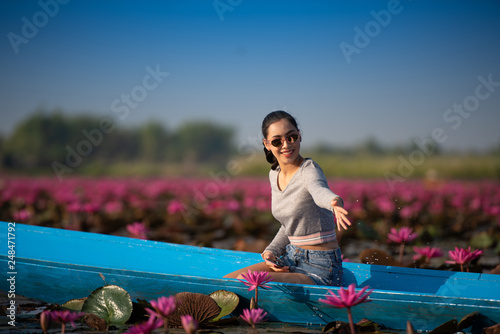 Young woman relaxing with beautiful lotus flower field at the Red Lotus Sea photo