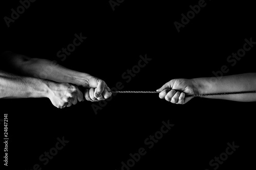 Tug war, man vs woman pulling rope in opposite directions unequally, uneven. copy space