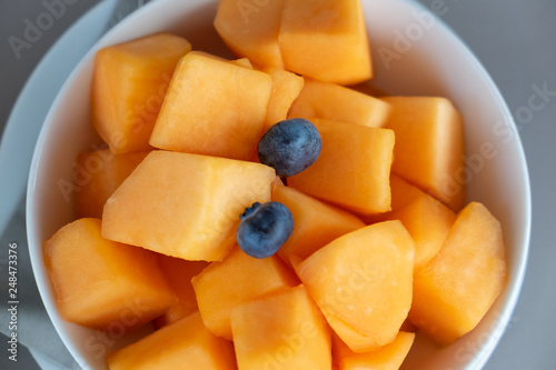 High angle view of a bowl of chopped melon and blueberry.
