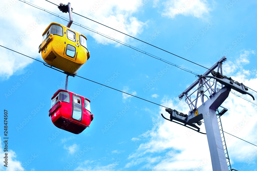 two cable cars passing near the tower in bright sky