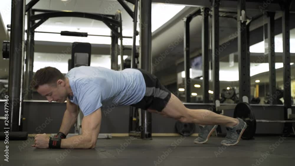 Muscular man practicing elbow plank exercise at the gym. Muscular man practicing elbow plank exercise at the gym.