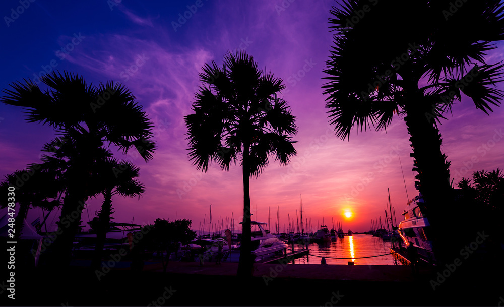 Obraz premium Beautiful sunset sky in the marina bay. View of harbor with yachts and motorboats. Sunset at the ocean.