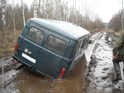 car stuck in a muddy deep pool in the forest