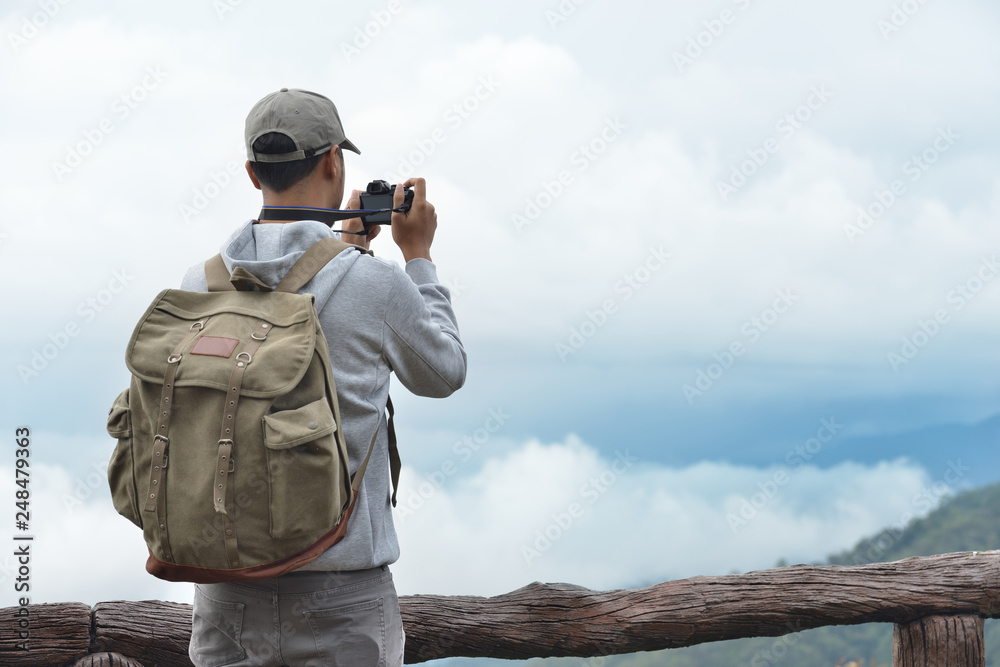 Obraz premium Young man travel photographer taking nature photo of mountain landscape (Thailand )