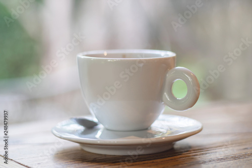 Coffee in white cup on desk as background