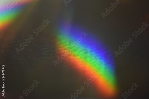 two light glares with a spectral gradient on a dark background, rainbow