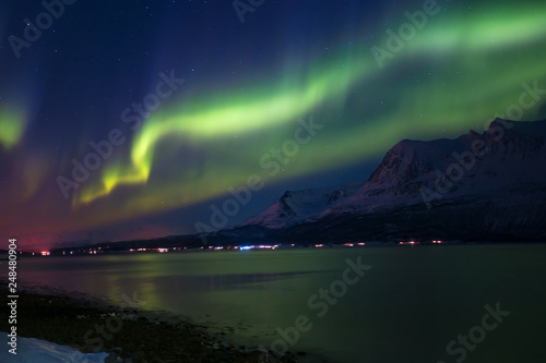 Northern lights in the sky over Tromso city,  Norway © muratart