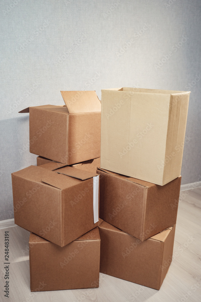 Moving in. Stack of cardboard boxes in the empty room. Moving in. Stack of cardboard boxes in the empty room.