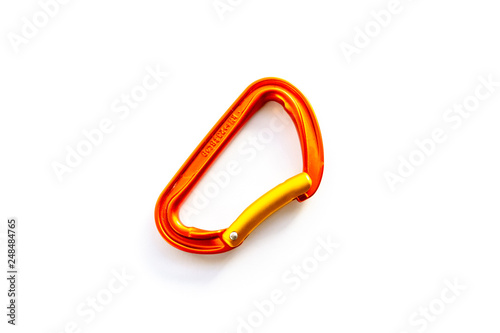 Centered orange solid bent gate carabiner (karabiner) used for clipping the rope in, isolated on white background, with copy space. Basic climbing gear with axis strength ratings.