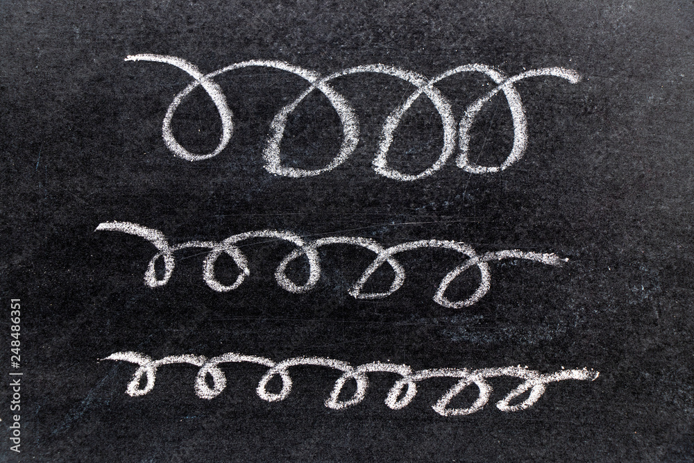 Fototapeta premium White chalk hand drawing in curve line shape on black board background