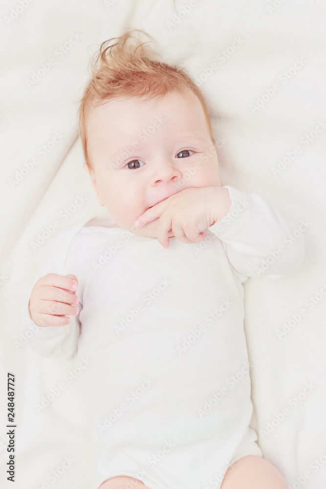 Happy child on the white blanket, blurred background Happy child on the white blanket, blurred background