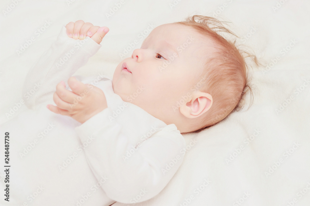 Happy child on the white blanket, blurred background Happy child on the white blanket, blurred background