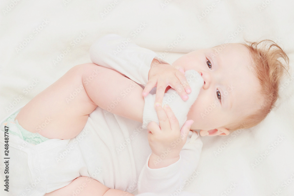 Happy child on the white blanket, blurred background Happy child on the white blanket, blurred background