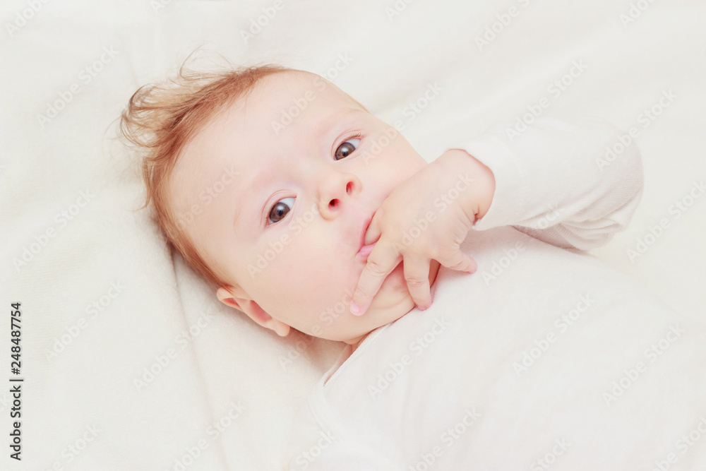 Happy child on the white blanket, blurred background Happy child on the white blanket, blurred background