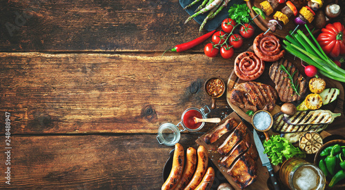 Grilled meat and vegetables on rustic wooden table photo