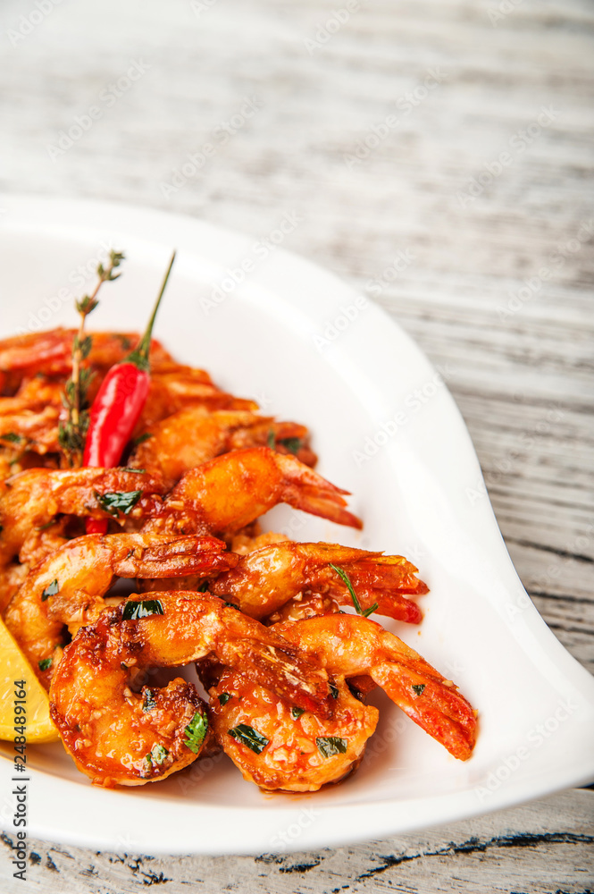 Grilled prawns with garlic, chilli peppers and tomatoes close-up and copy space Grilled prawns with garlic, chilli peppers and tomatoes close-up and copy space