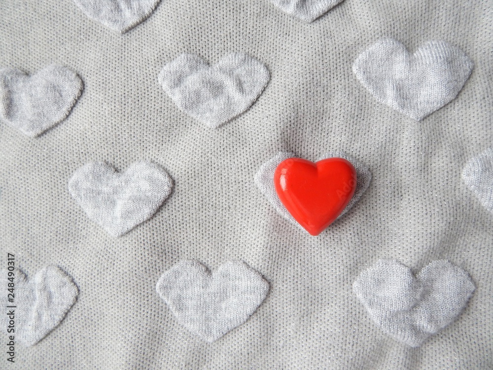 Obraz premium Grey heart shaped knitwear texture with red heart