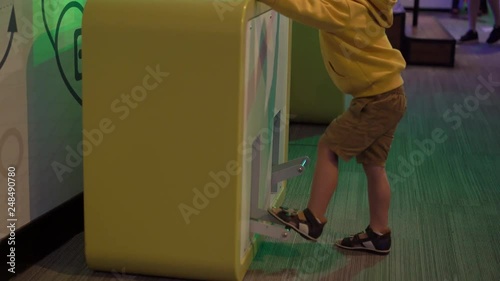 Little boy visiting a science museum for children. He pumps an air bubbles into the viscous fluid photo
