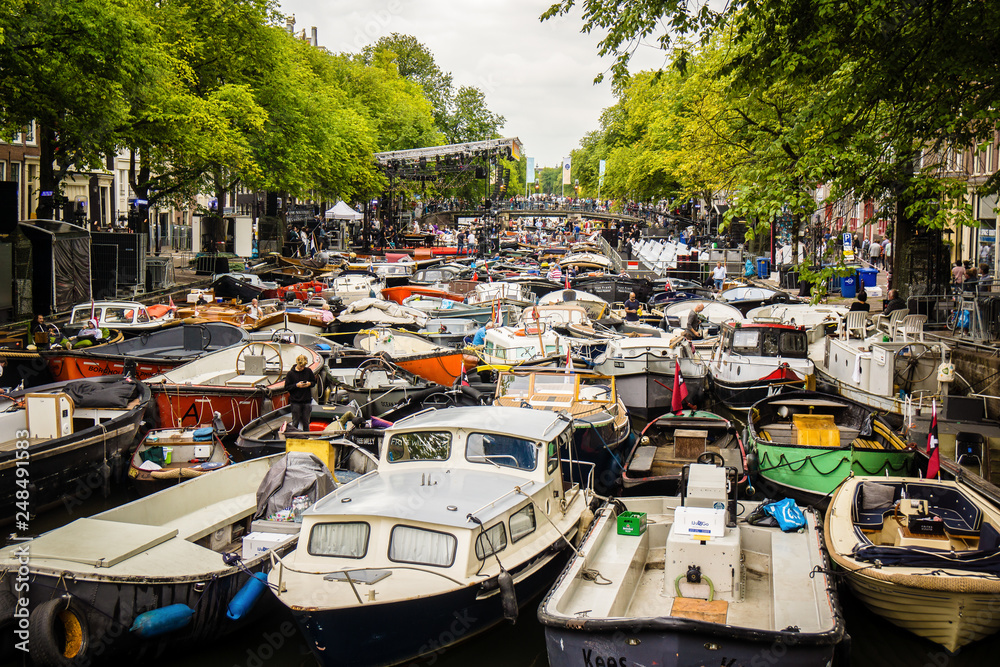 Naklejka premium Amsterdam many boats floating in canal water Holland river