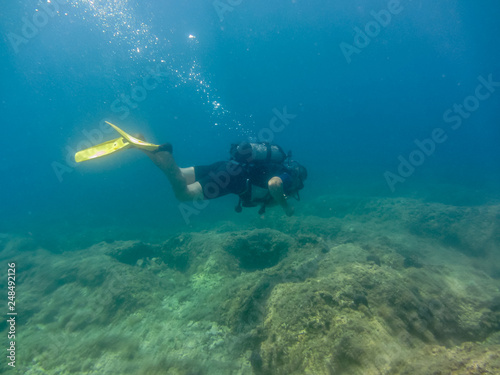 Young man with diving equipment  swimming underwater.Scuba diving  in Ionian sea. Greece, Corfu  vacation summer © SnowMan
