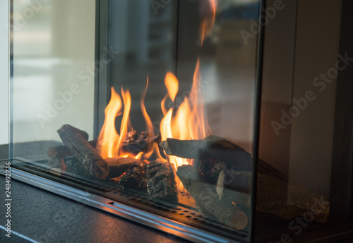 Obraz na plátně a fire burns in a glass fireplace, radiates heat