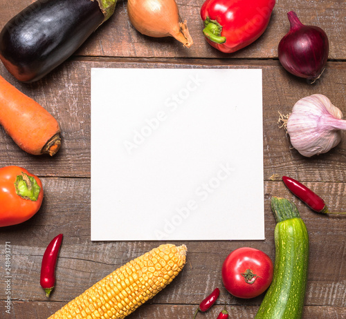 Layout with various vegetables and fruits and white paper card for text . photo