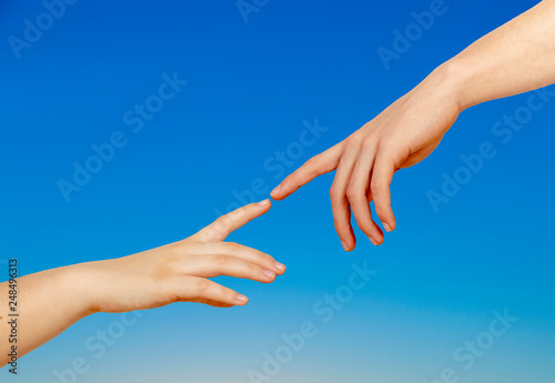 Two hands on a light background, a replica of the plot of Michelangelo's The Creation of Adam