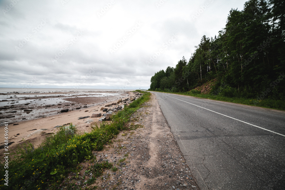 Old asphalt road near the coast of the cold sea in northern Europe