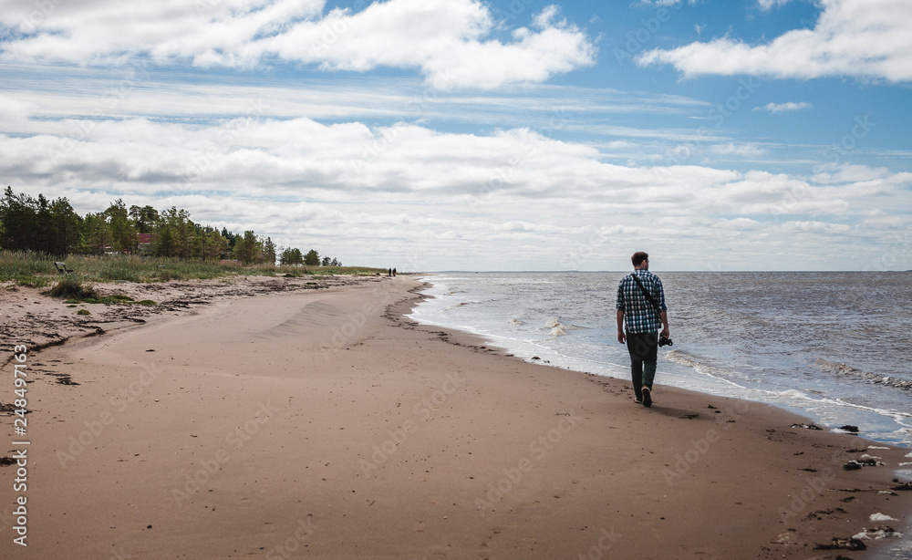 Photographer walks along the coast of the North Sea