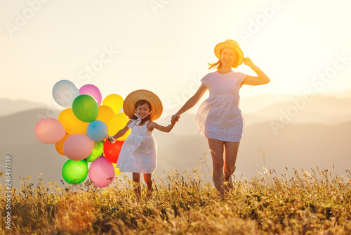 happy family mother and child with balloons at sunset in summer.