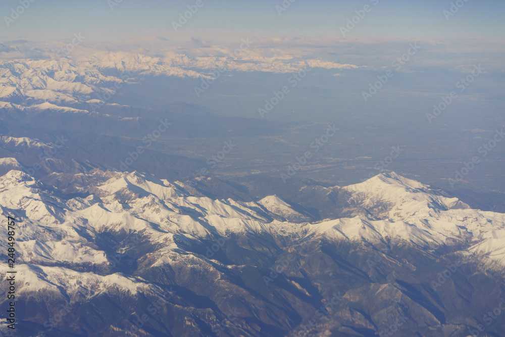 View of the Alps mountains through an airplane window