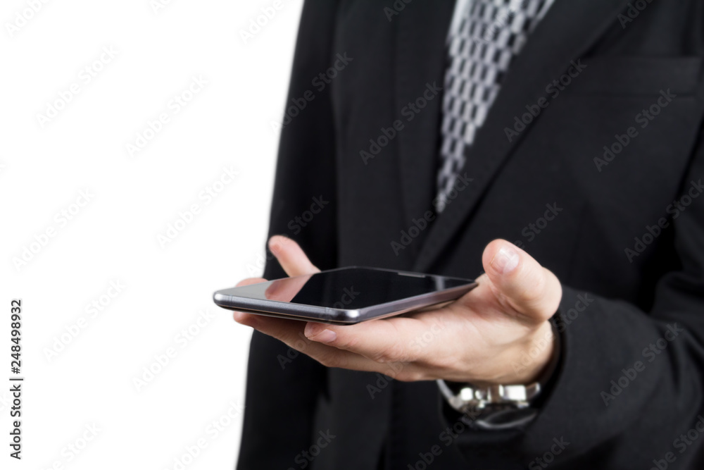 Businessman in Black Suit and Tie Holding Smartphone in Hand Against White Background Businessman in Black Suit and Tie Holding Smartphone in Hand Against White Background