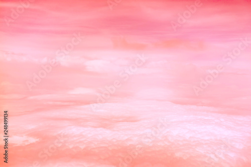 Living Coral color of the Year 2019. Aerial view of sky with fluffy clouds. Retro toned abstract background.