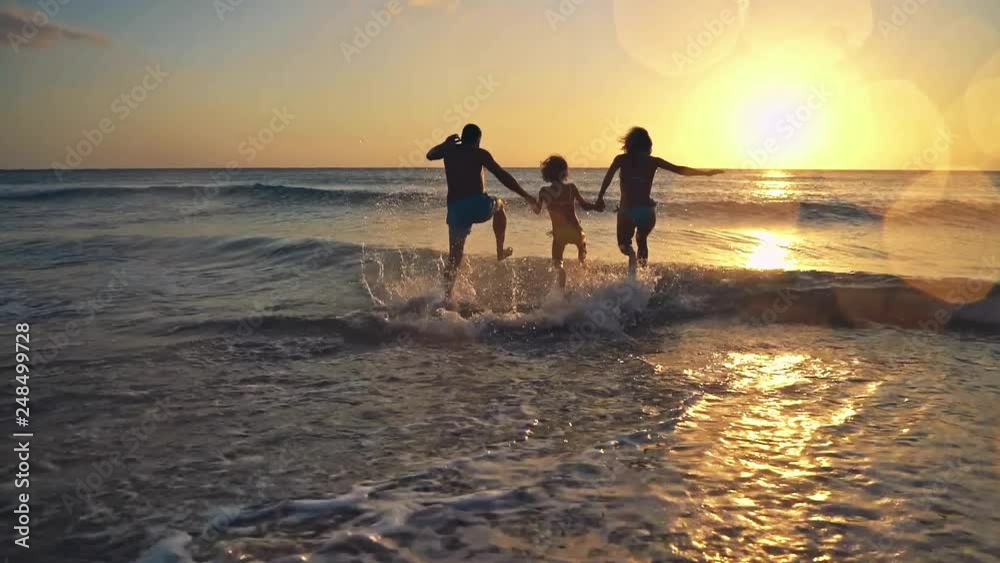 Happy family having fun on summer vacation. Father, mother and child playing in sea. Active healthy lifestyle concept