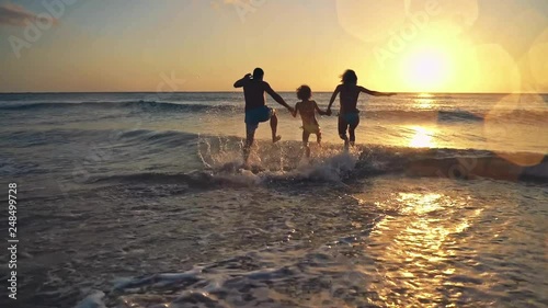 Happy family having fun on summer vacation. Father, mother and child playing in sea. Active healthy lifestyle concept