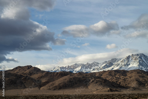 snowy mountains brown desert hills clouds sky Eastern Sierras of California winter landscape