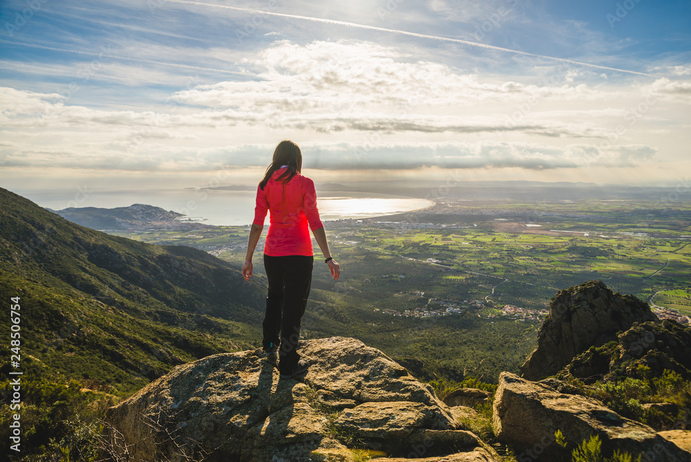 Naklejka premium Girl on top of a cliff watching a beautiful landscape