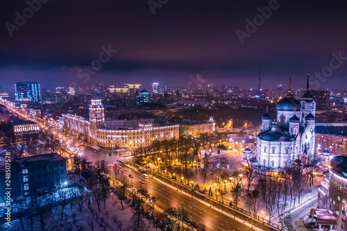 Arial view of Voronezh Main South-Eastern Railway Building tower in night, symbol of Voronezh and evening cityscape with rads, parks and traffic, drone shot