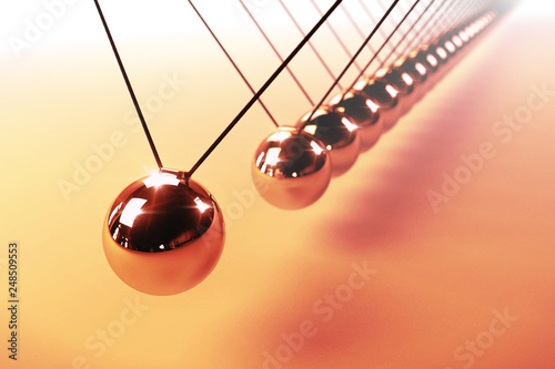 Newton's cradle, action and reaction concept, series of swinging spheres, device that demonstrates conservation of momentum and energy photo