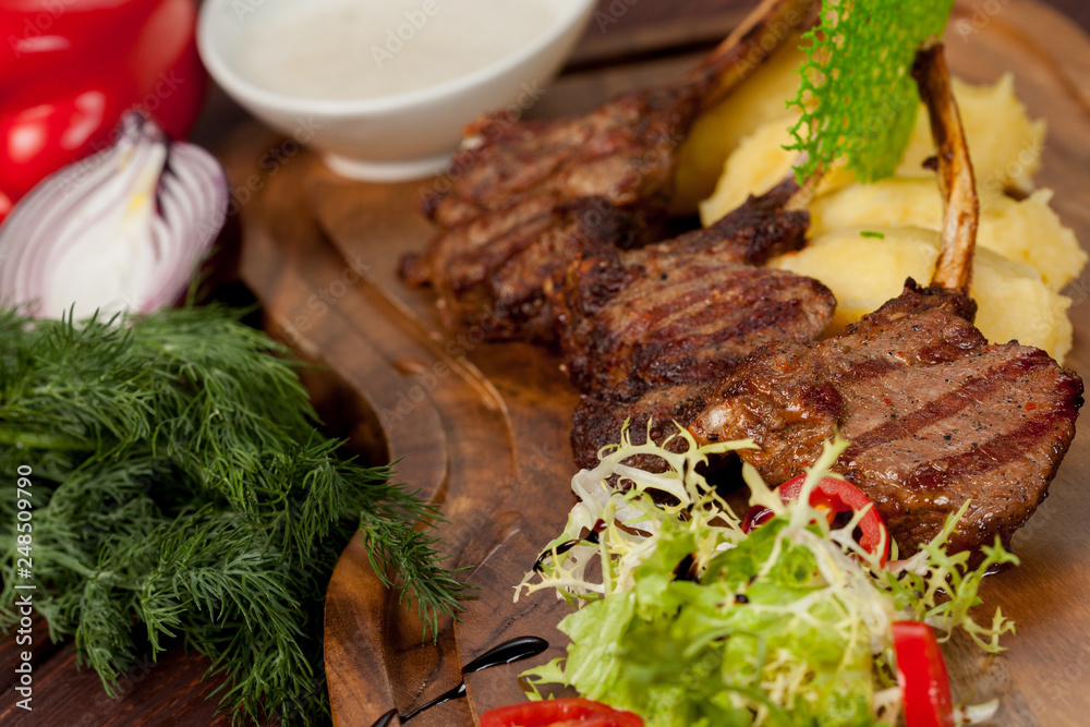 juicy, fried, tender steak with vegetables and sauces on a special stand juicy, fried, tender steak with vegetables and sauces on a special stand
