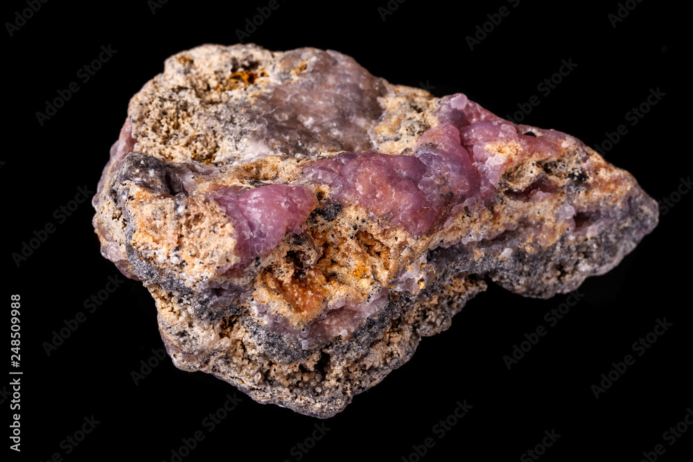 Macro pink Smithsonite mineral stone on microcline on black background Macro pink Smithsonite mineral stone on microcline on black background
