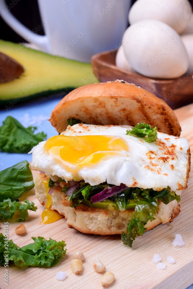 Sandwich with fried egg and salad with kale