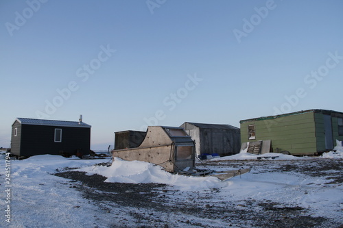 Cabins and an Inuit sled covered with slight snow near the community of Rankin Inlet, Nunavut, Canada photo