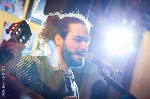 Canvastavla Guitarist and singer during a musical performance.