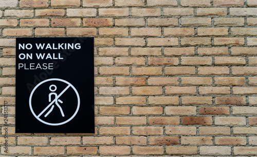 No Walking On Wall Please sign on rustic brick wall - high quality texture / background and sign