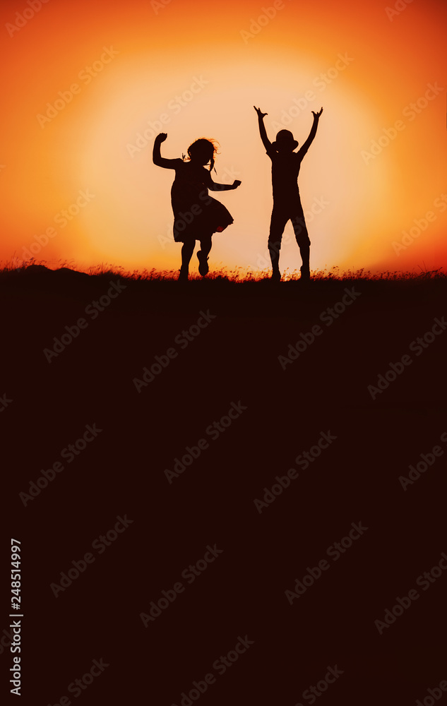Silhouette of happy children boys and girls jumping and dancing in sunset sky evening time background as successful, happiness and careless concept Silhouette of happy children boys and girls jumping and dancing in sunset sky evening time background as successful, happiness and careless concept