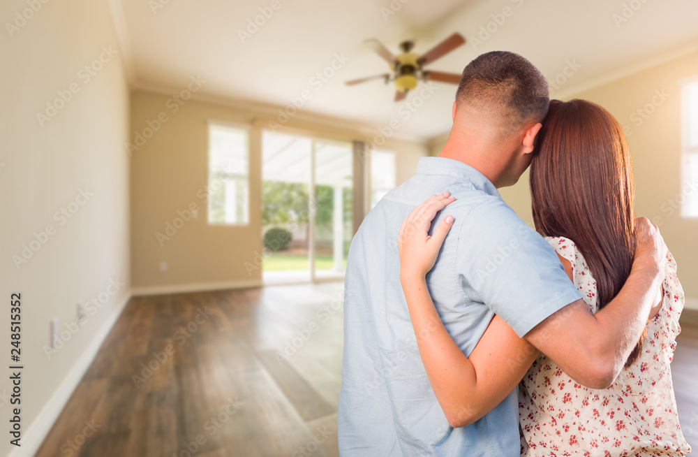 Young Military Couple Looking At Empty Room of New House Young Military Couple Looking At Empty Room of New House