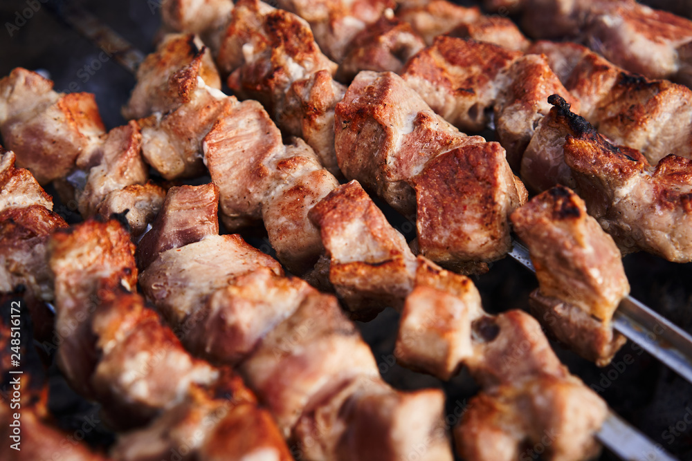 Grilling marinated shashlik on a grill. Shashlik is a form of Shish kebab popular in Europe and other places Grilling marinated shashlik on a grill. Shashlik is a form of Shish kebab popular in Europe and other places